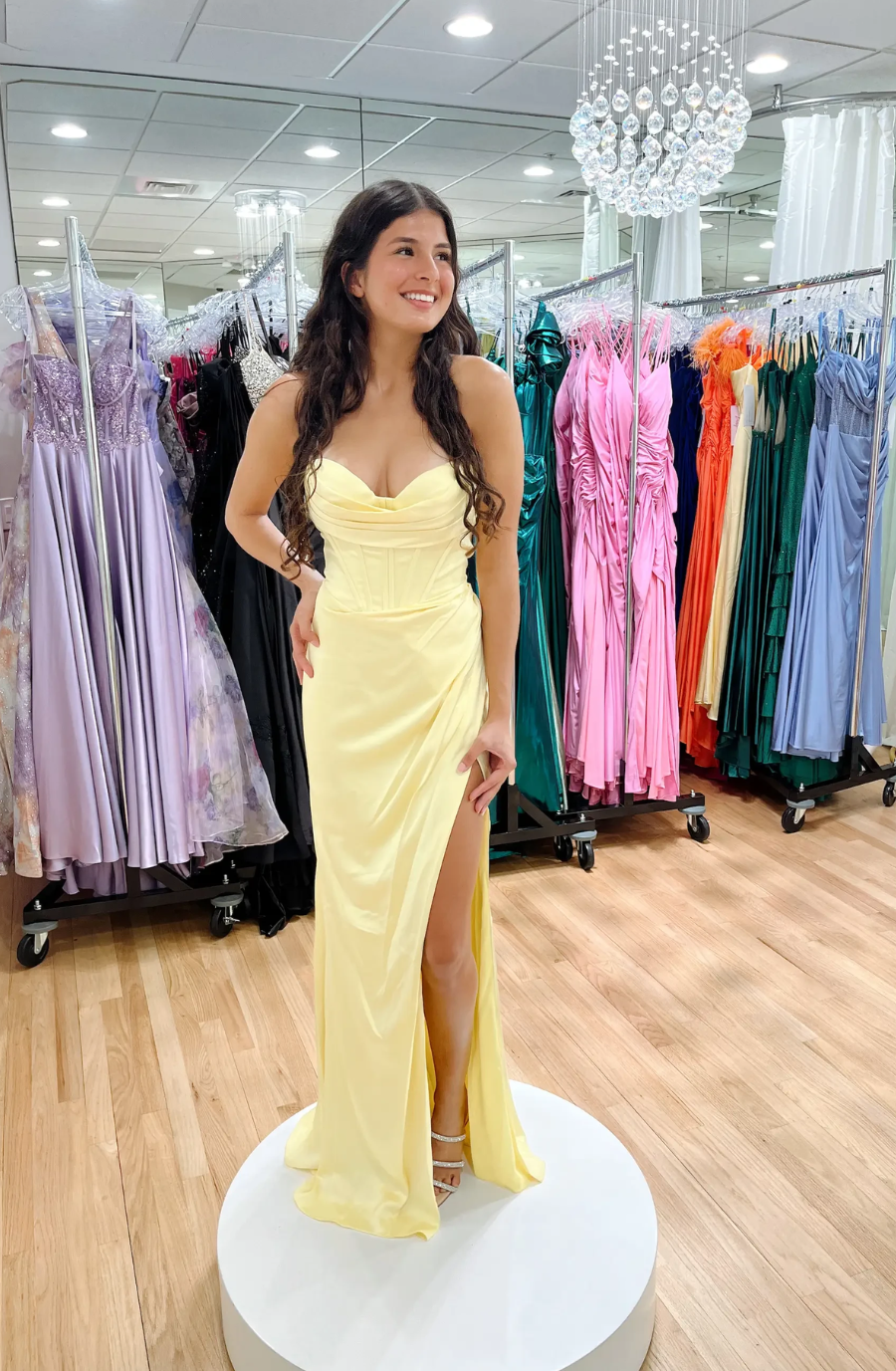 model is wearing a sleeveless yellow prom dress