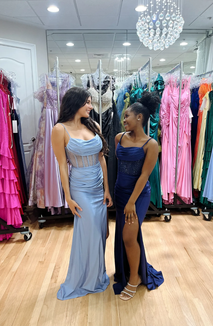 two models are wearing sleeveless blue prom dresses