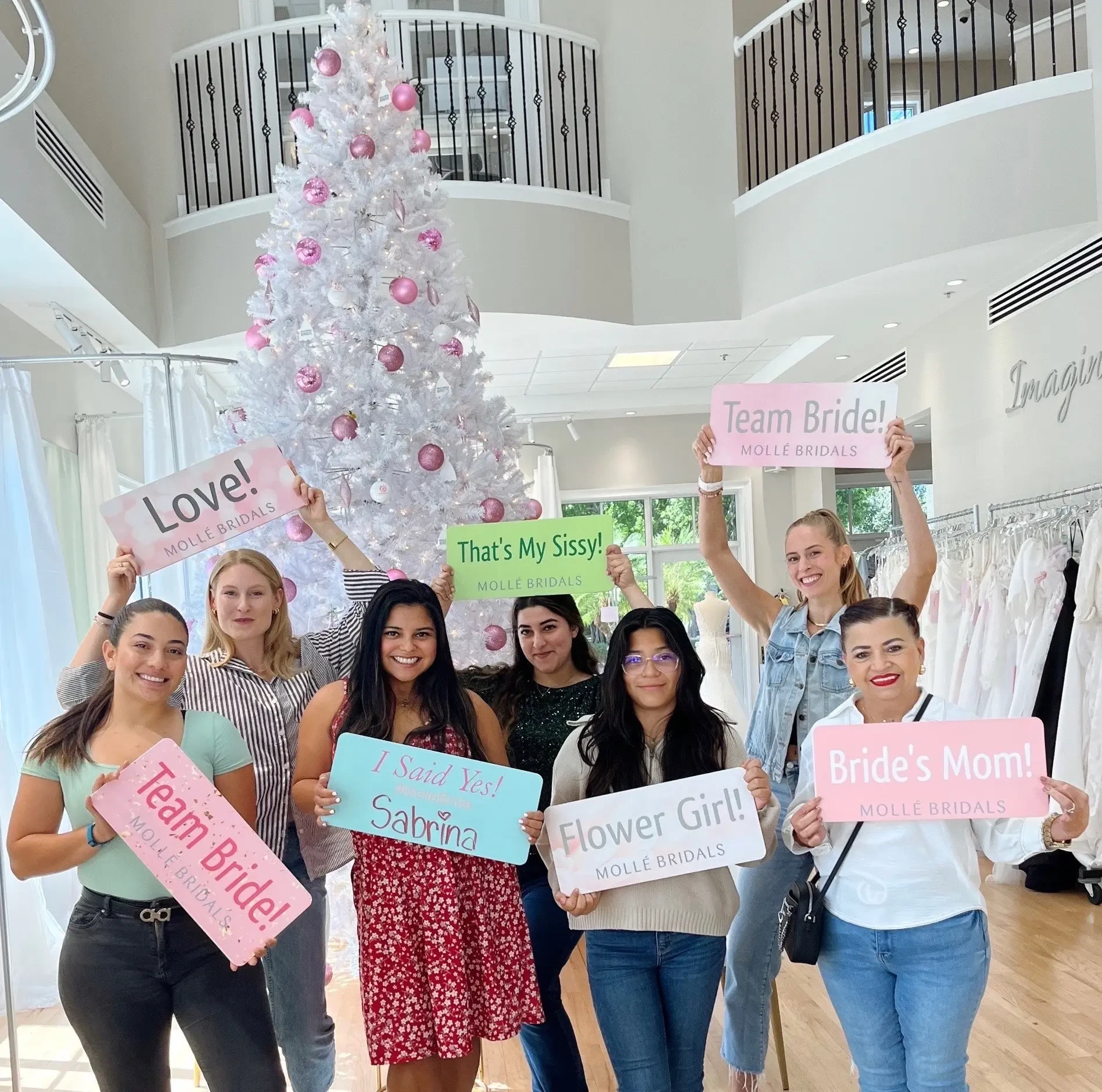 A joyful group of women holds up colorful signs such as 
