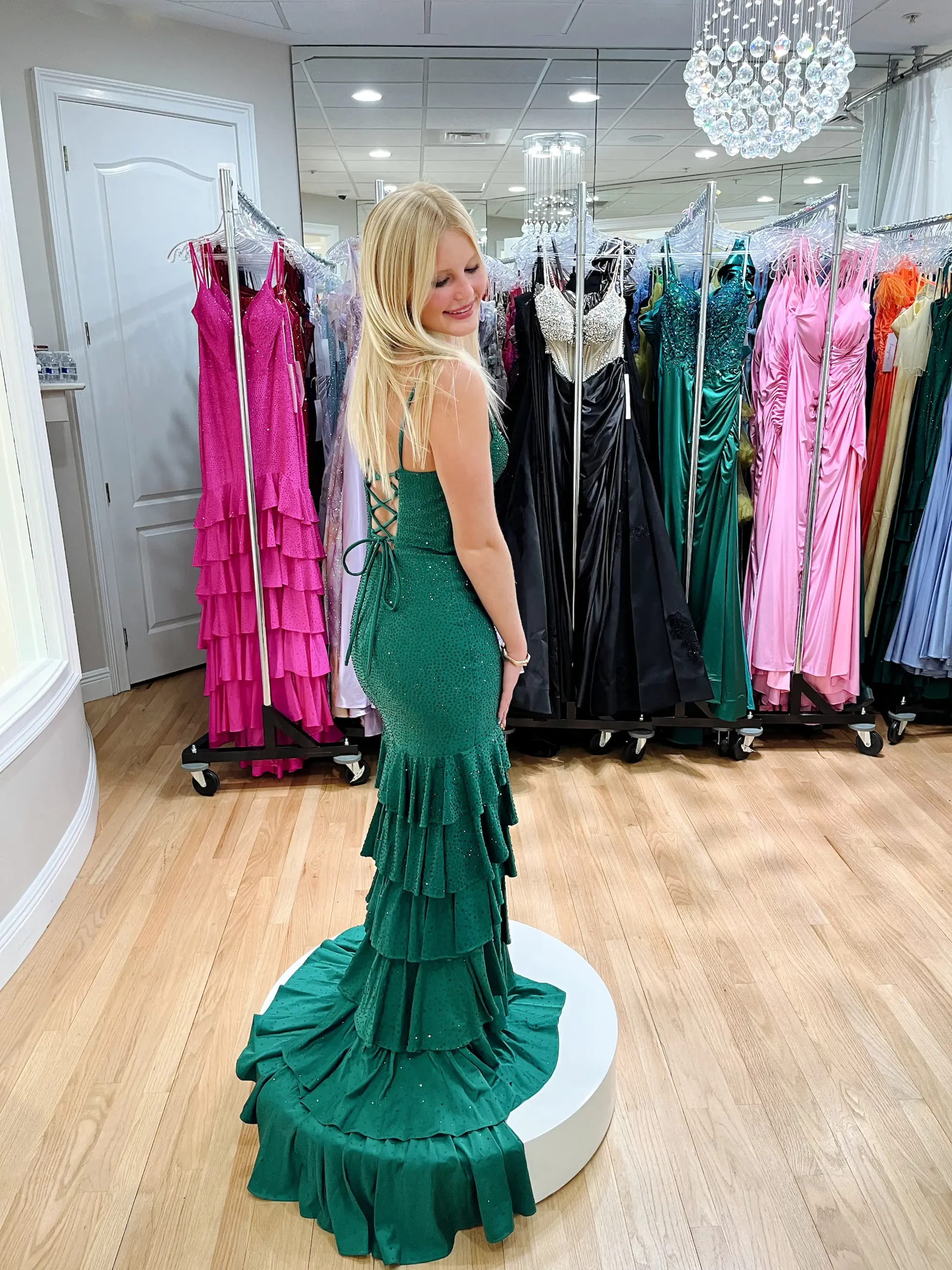 model is wearing an emerald green prom dress