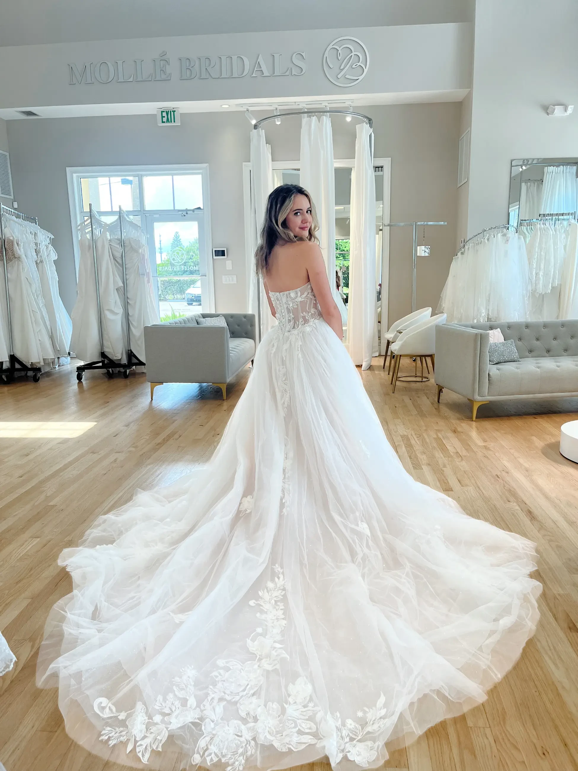 model is wearing a strapless wedding gown with a long train