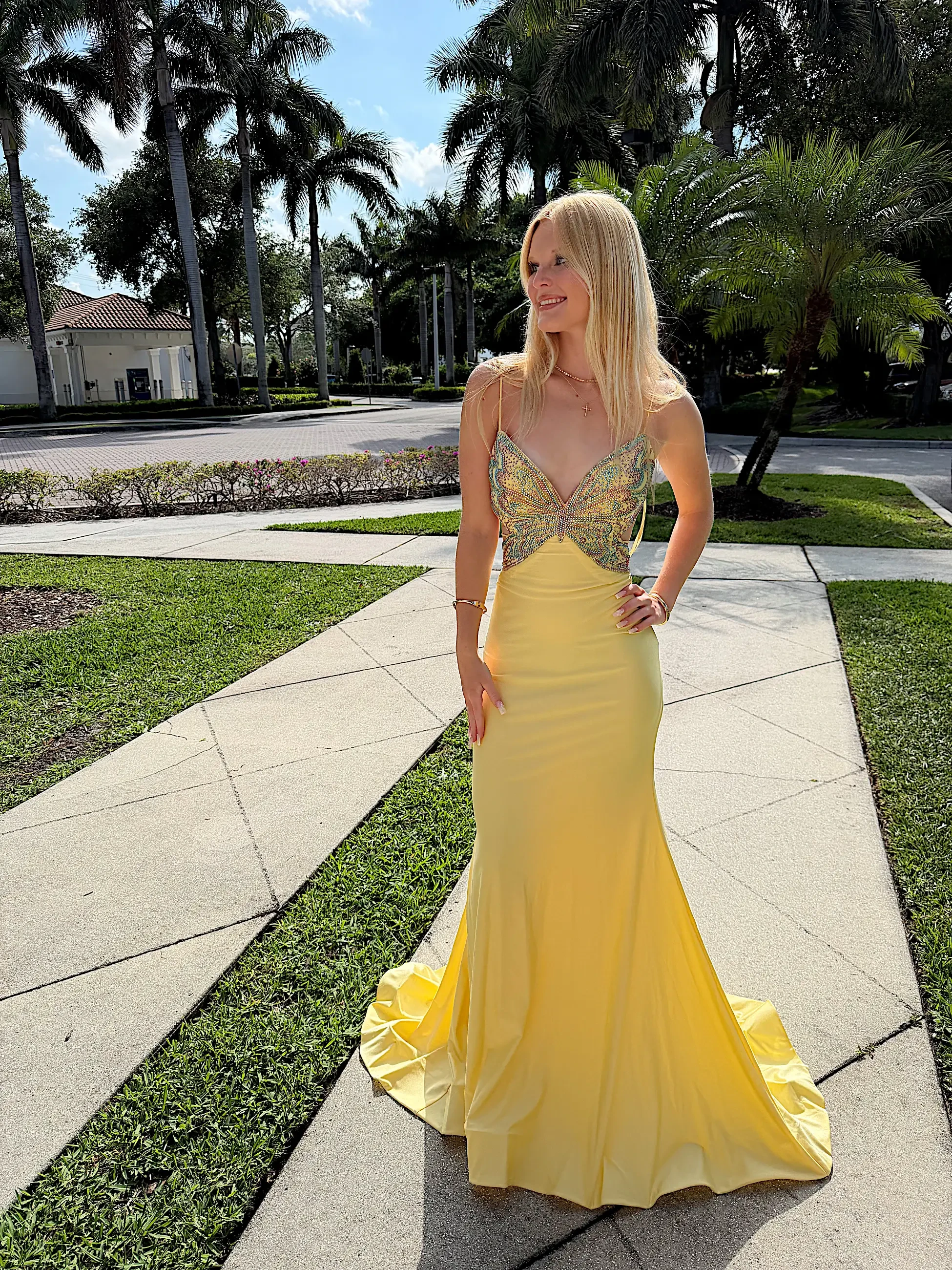 image shows a model wearing a yellow prom dress