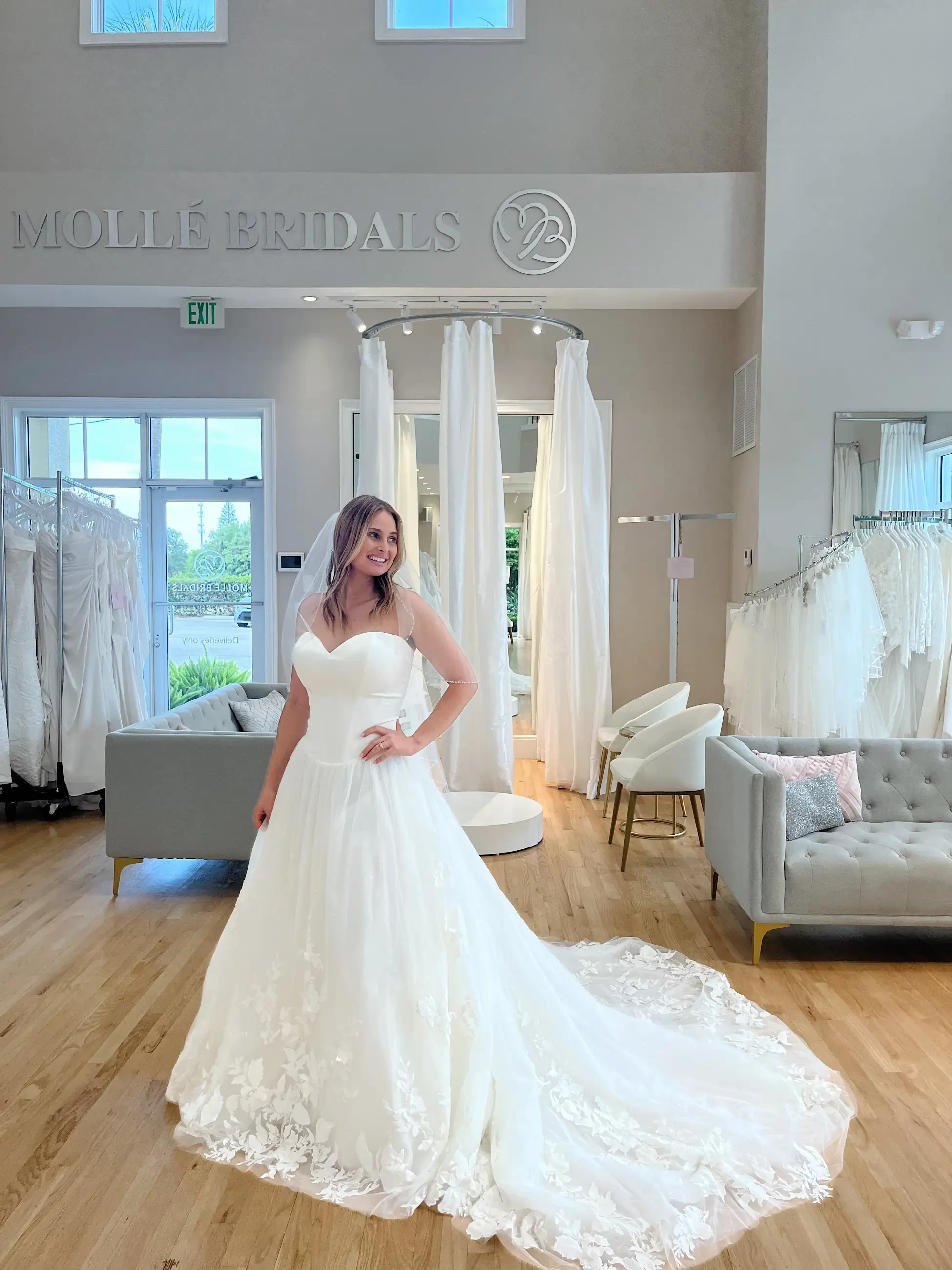 model is wearing a strapless wedding dress with a long train