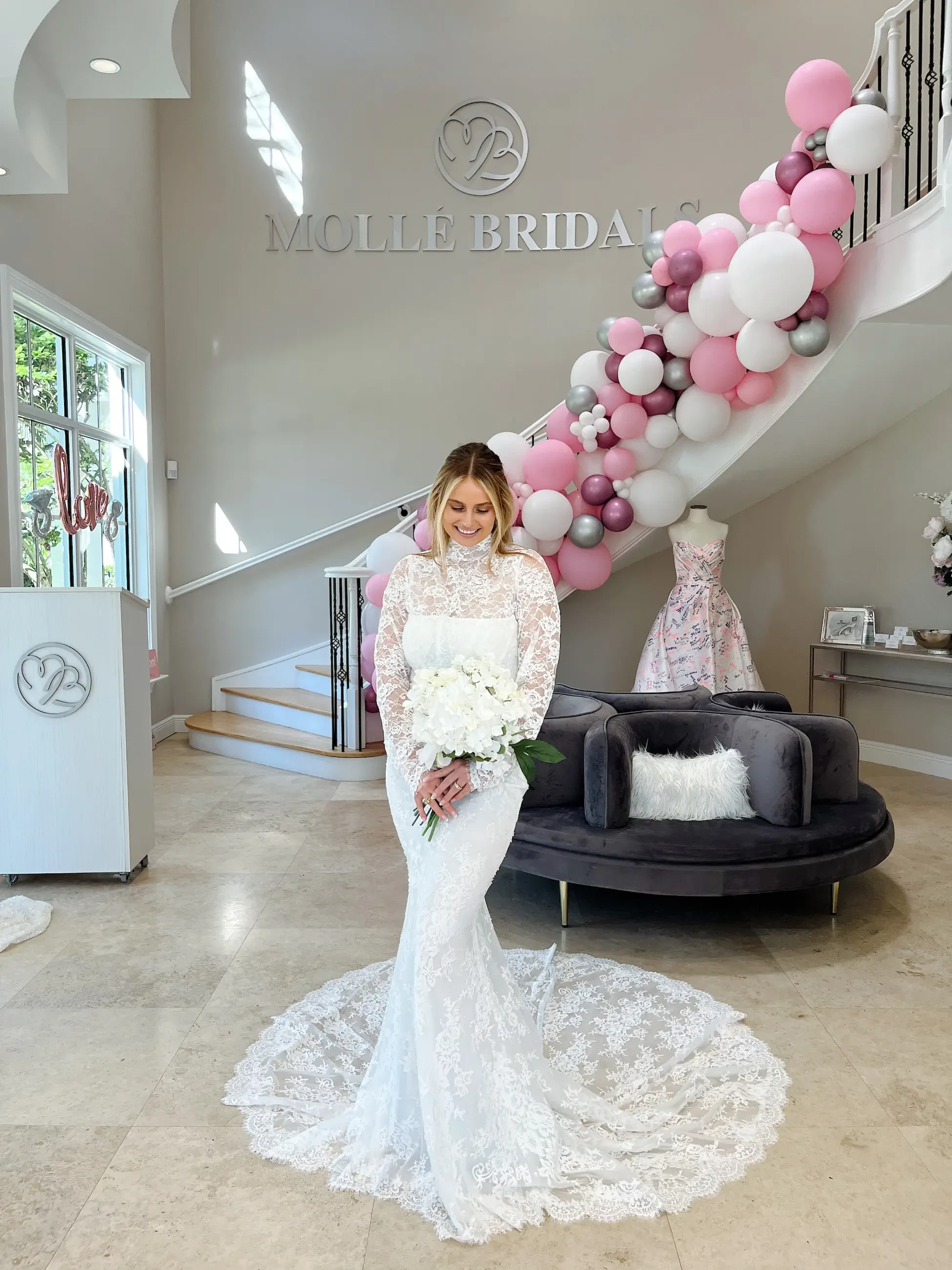 model is wearing a high neckline long sleeve lace wedding gown
