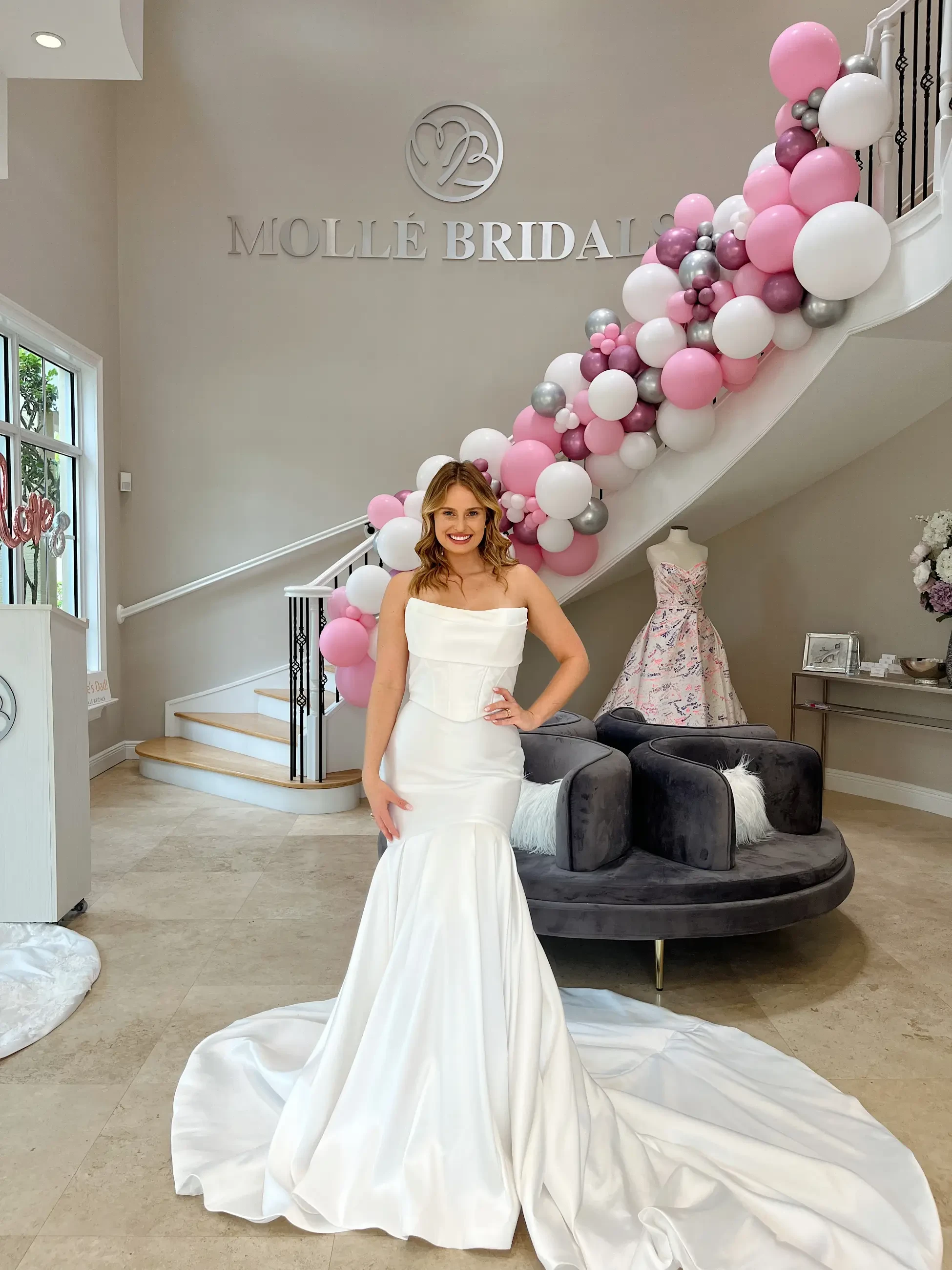 model is wearing a strapless mermaid wedding gown with a long train