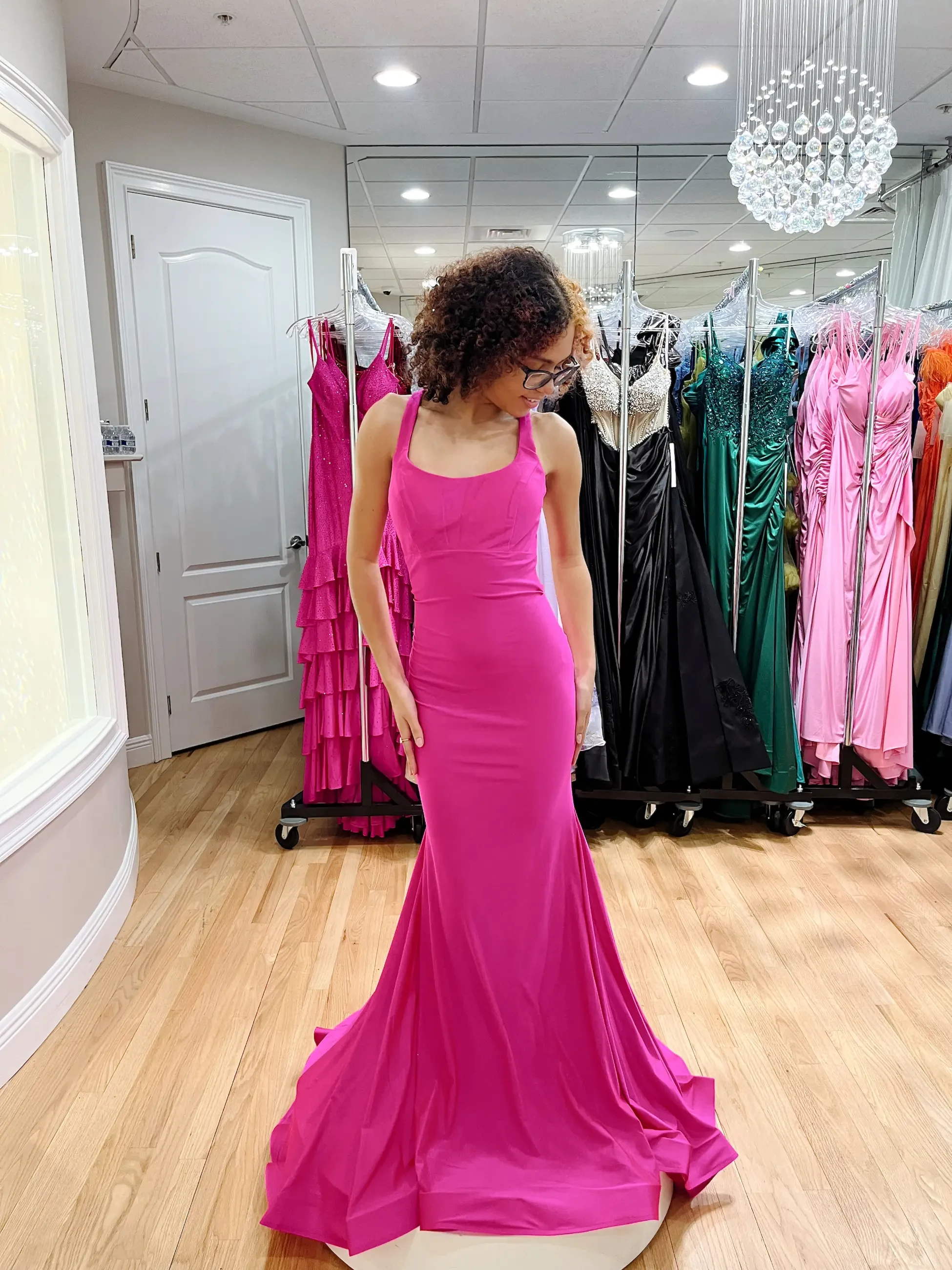 model is wearing a hot pink sleeveless prom dress