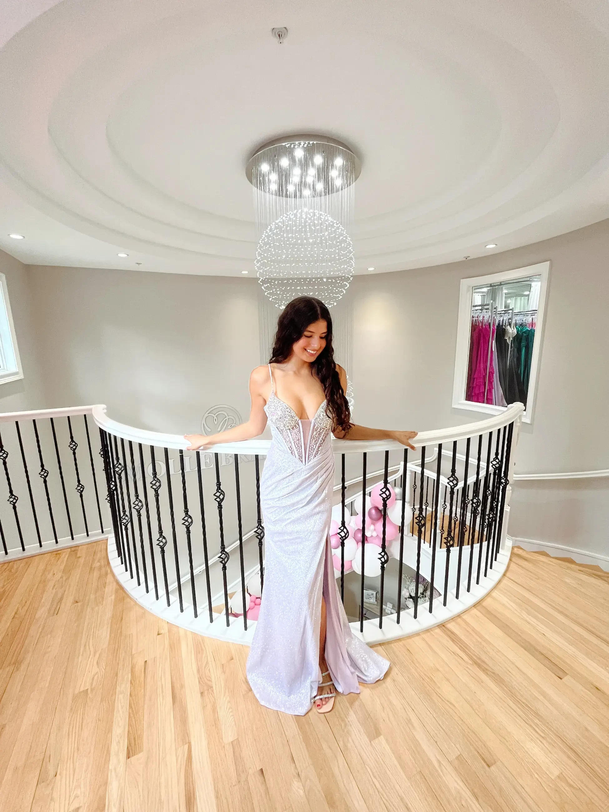 model is wearing a sleeveless silver prom dress