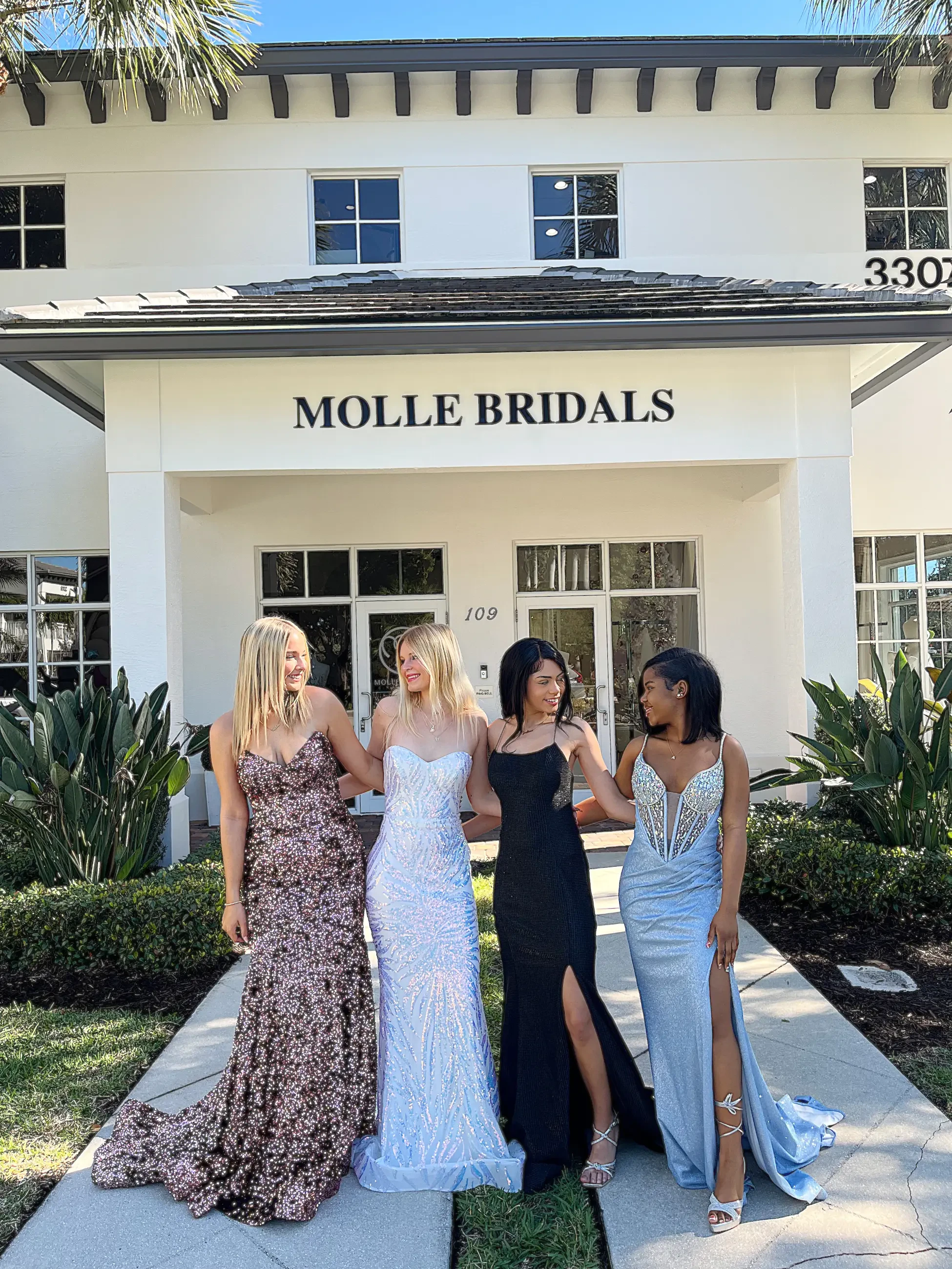 image shows four models wearing prom dresses