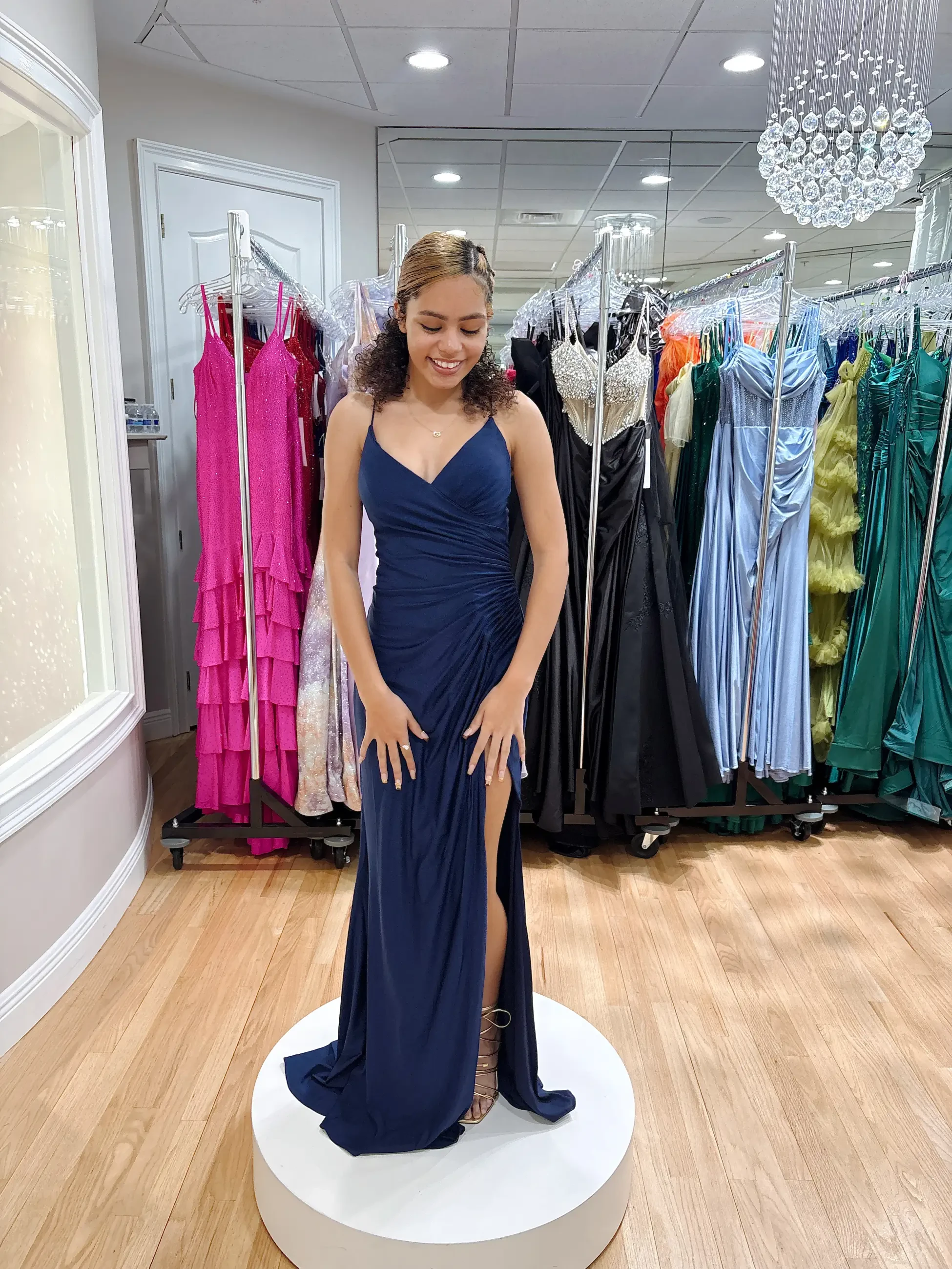 model is wearing a sleeveless navy blue prom dress