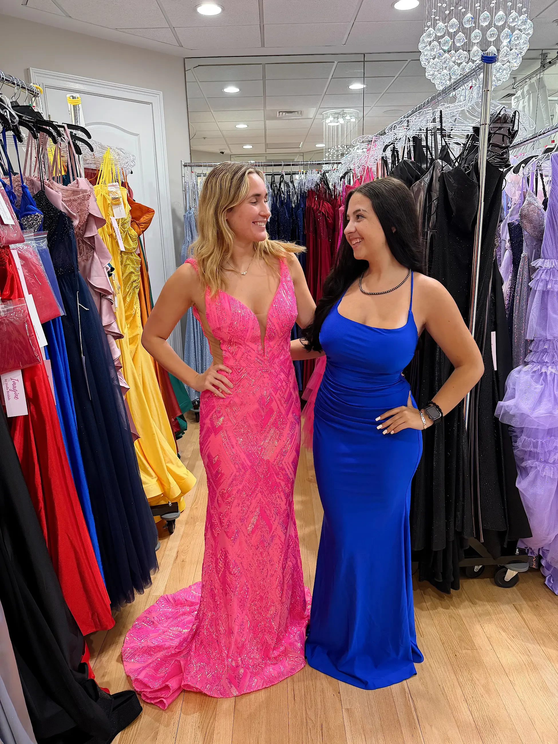 image shows two models wearing prom dresses