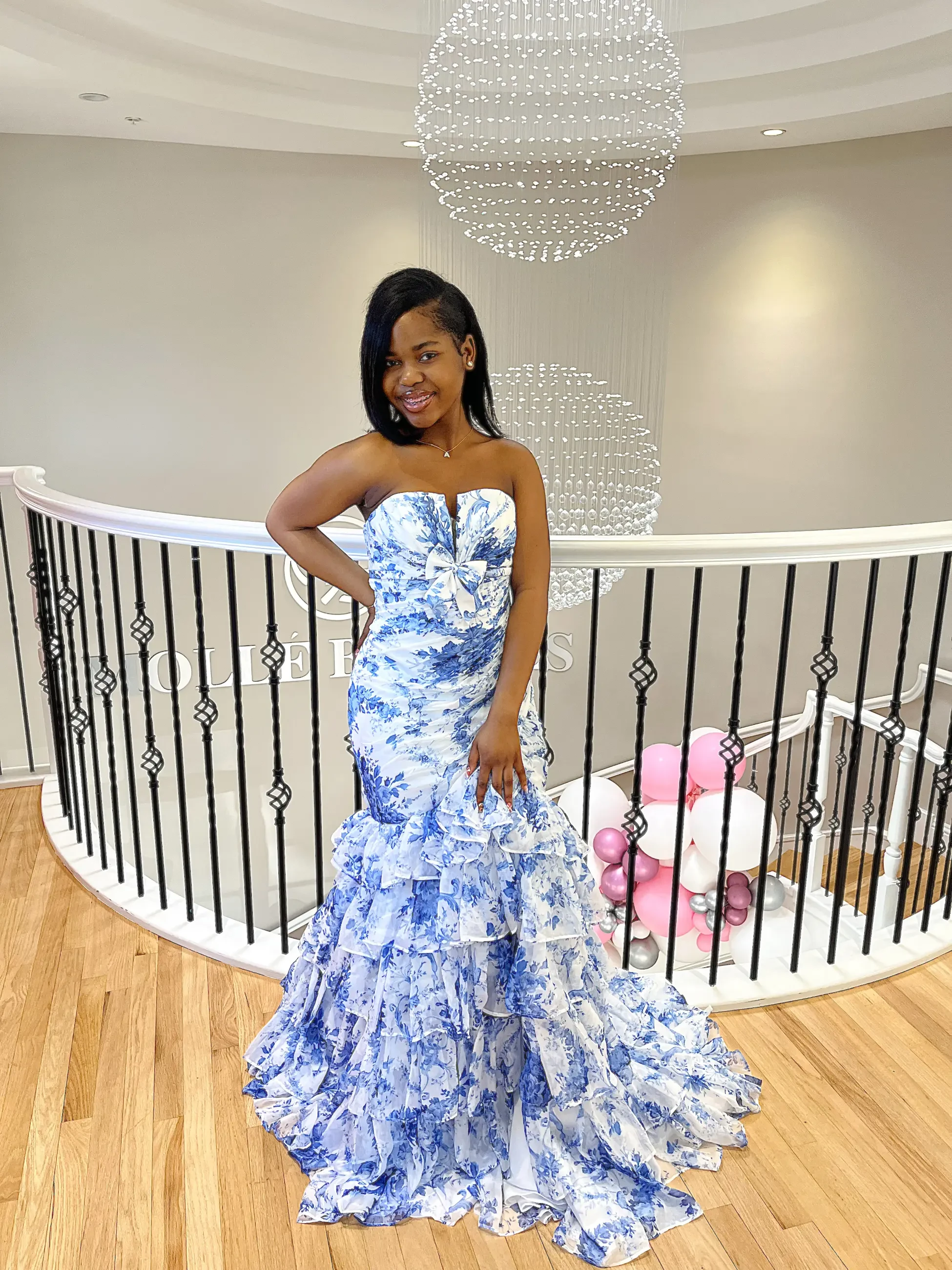 model is wearing a strapless floral prom dress
