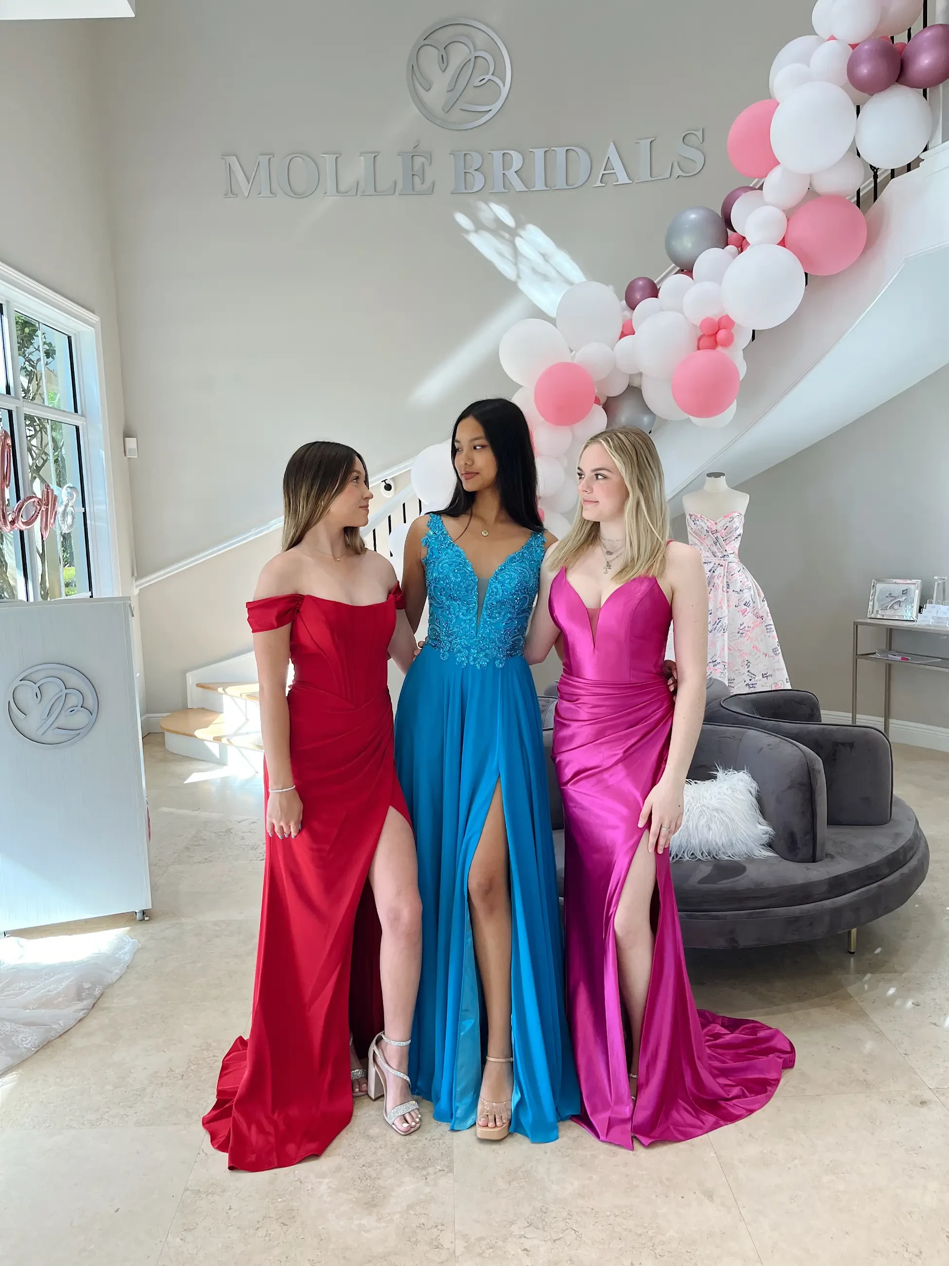 image shows three models wearing evening gowns from molle bridals