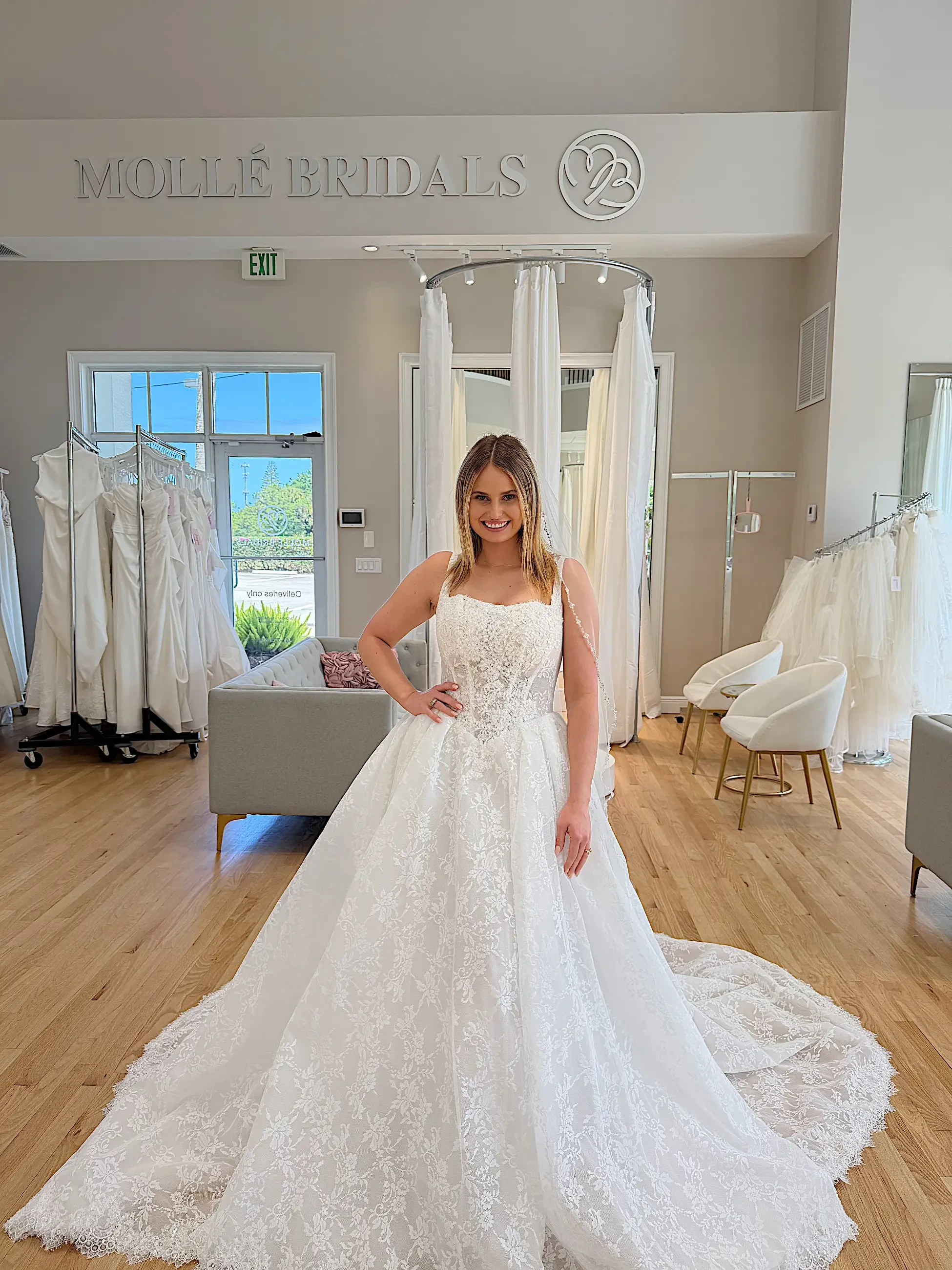 image shows model wearing a sleeveless lace ball gown