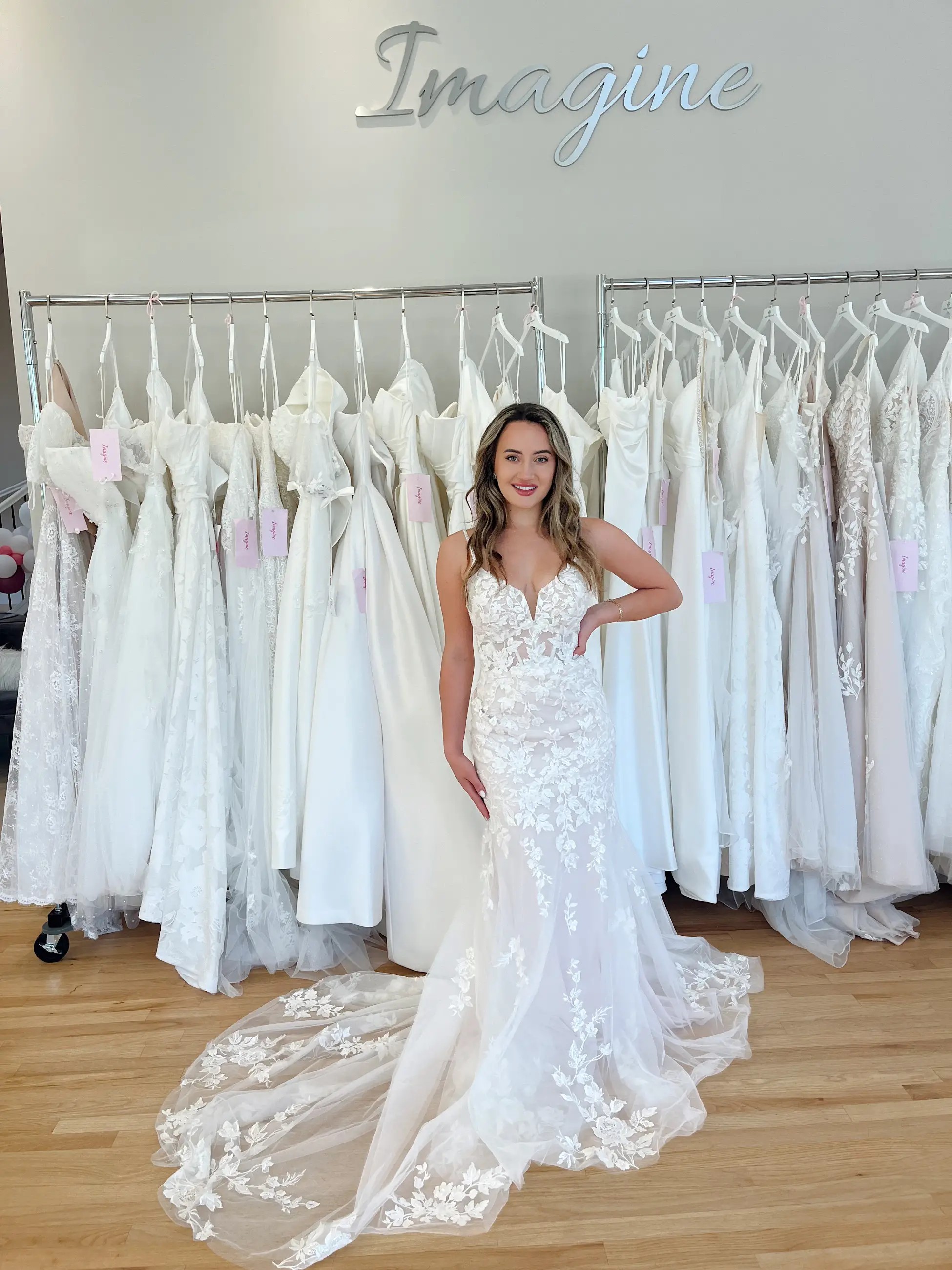 Model is wearing a wedding dress with a fit and flare silhouette and spaghetti straps and a v-neckline with a tulle skirt overlay