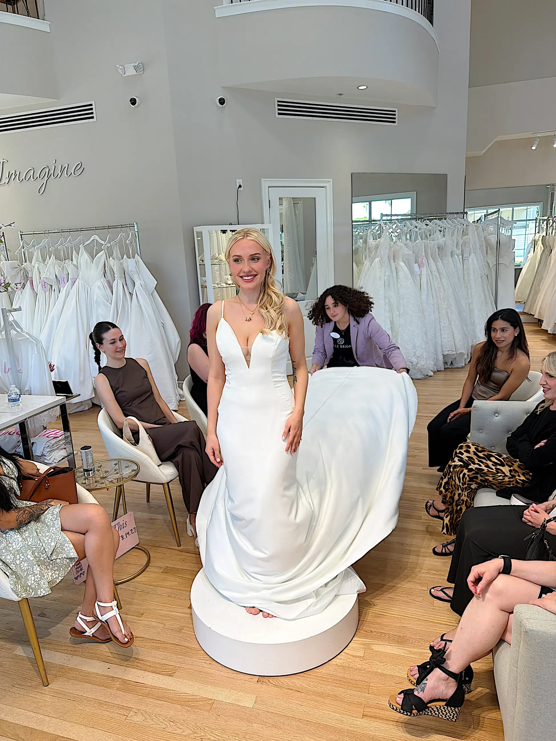 image shows a bride trying on a wedding gown