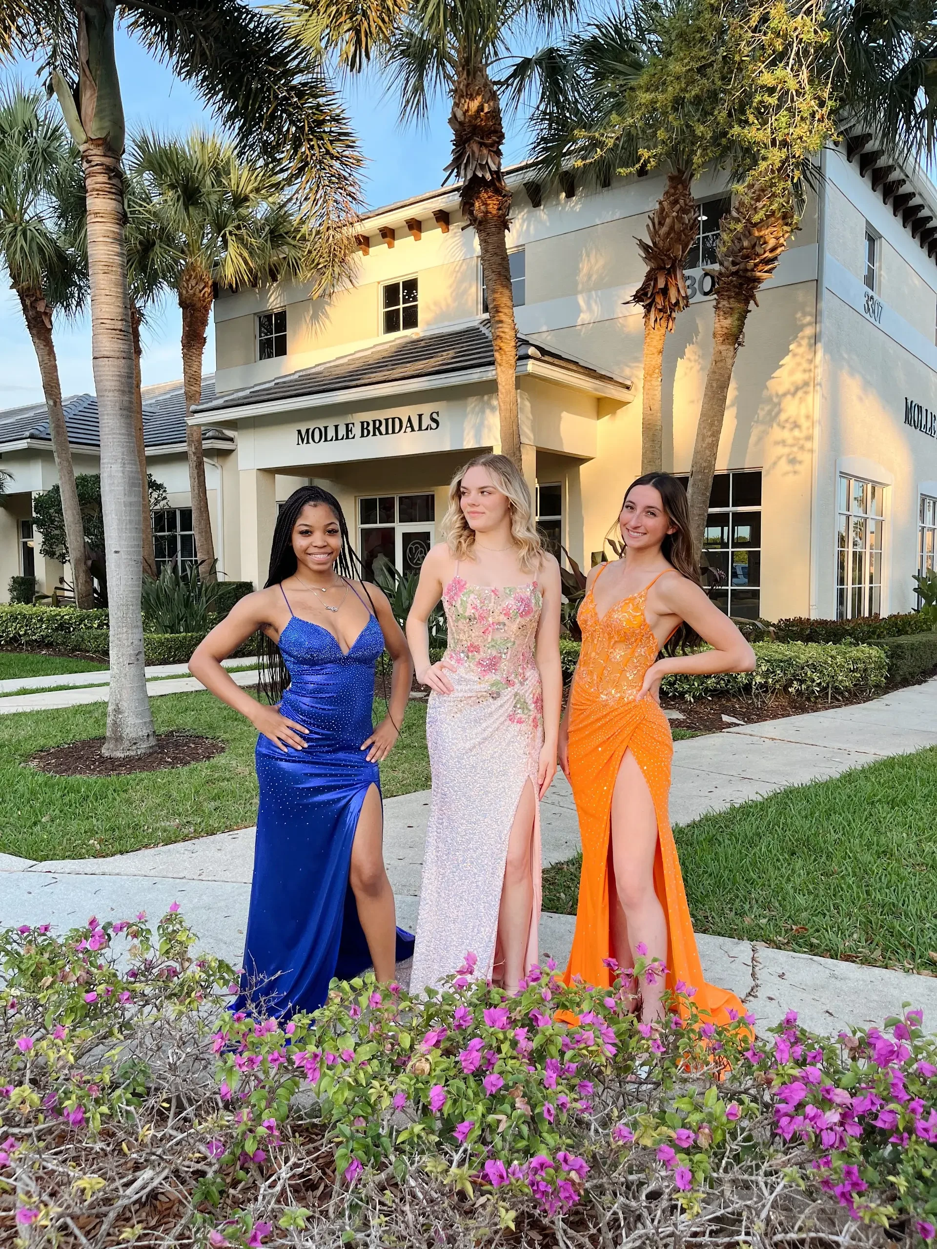 image shows three models wearing evening gowns in different colors 