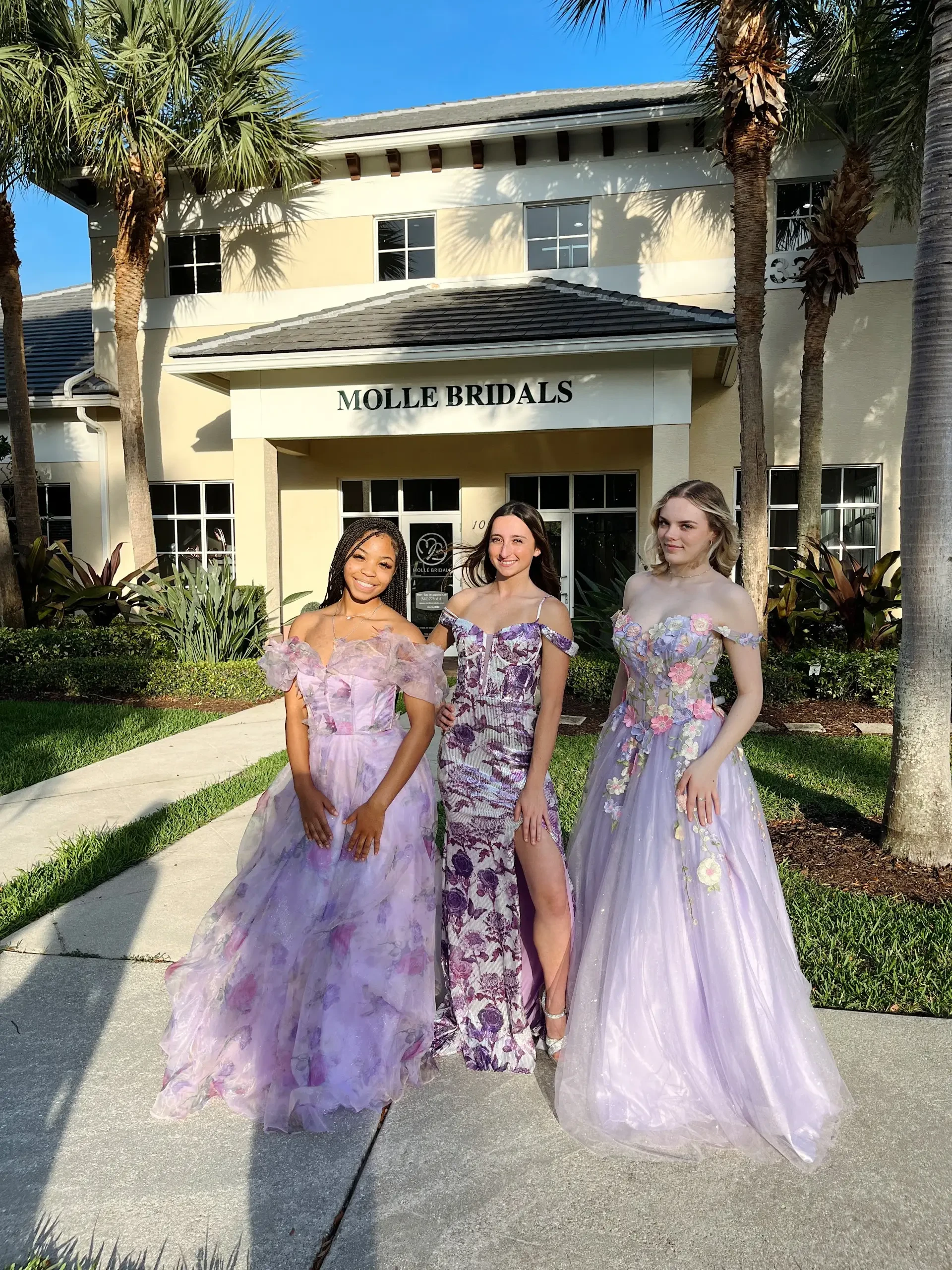 image shows three models wearing light purple evening gowns from molle bridals