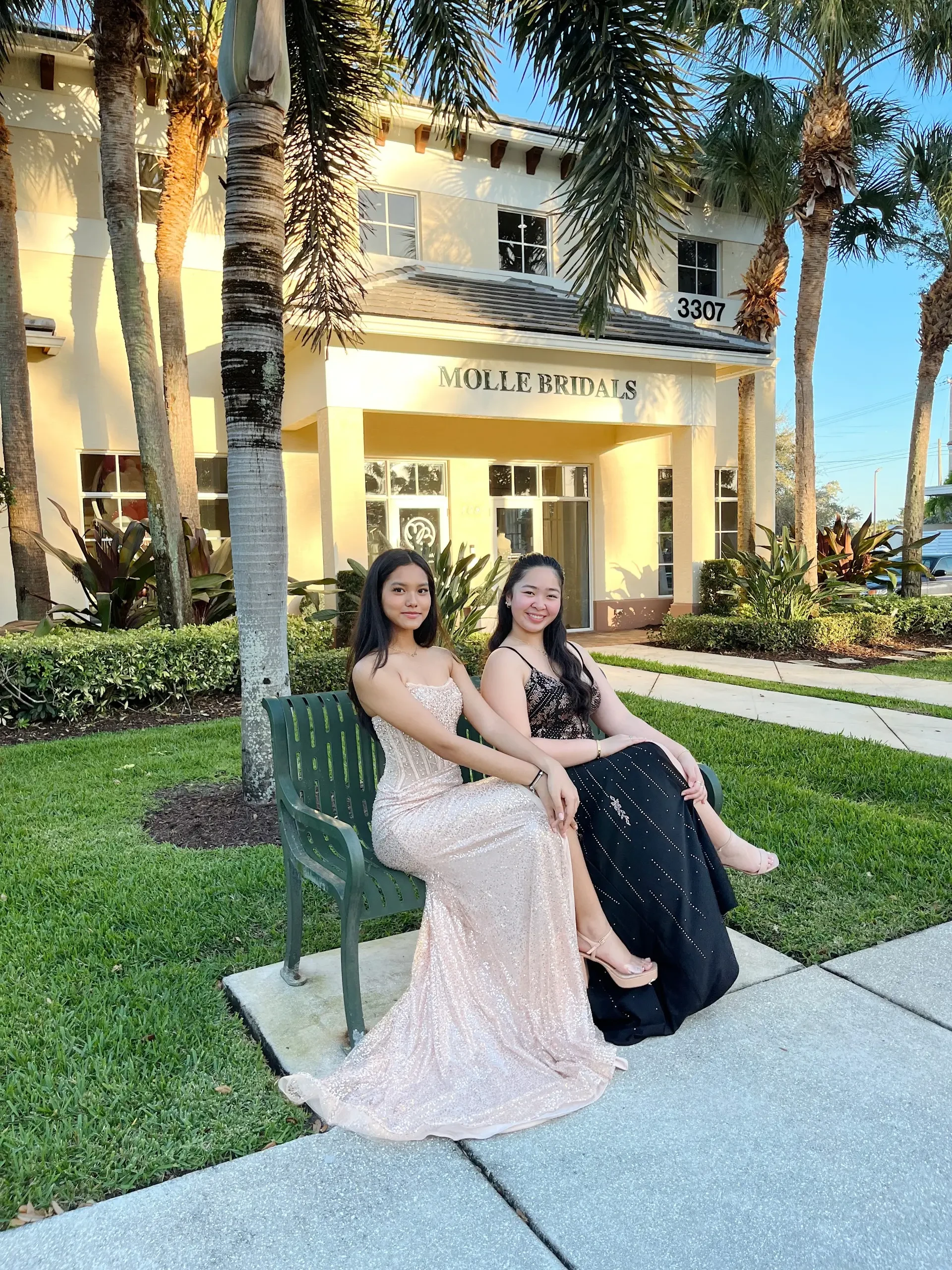 image shows two models wearing an evening gown from molle bridals
